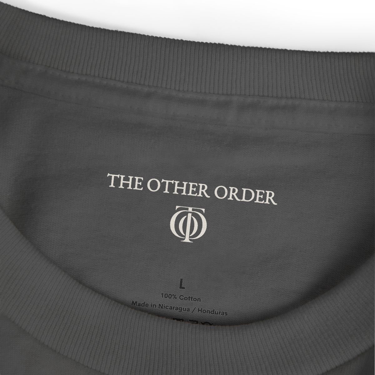 The Other Order NO NAME TO DROP., graphic study tee in obsidian — collar and printed neck label